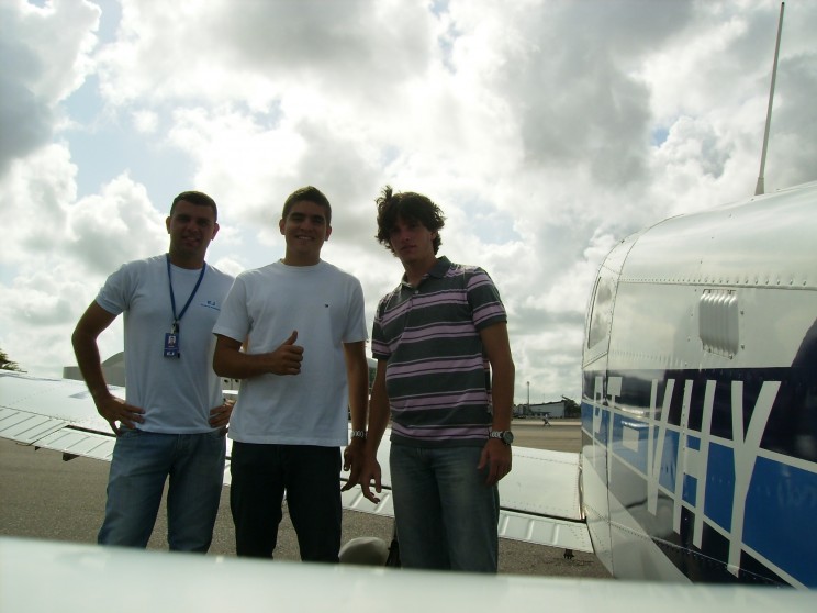 O instrutor Varela, Bruno e Guilherme diante da aeronave: PT-VHY utilizada na navegação.