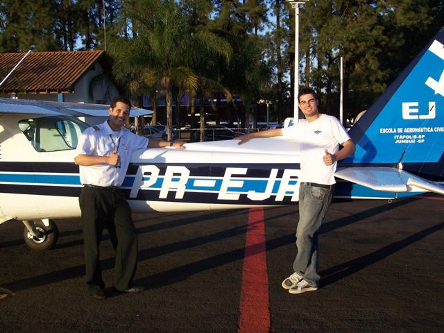 Instrutor Lucas e aluno Bruno posam a frente da aeronave.